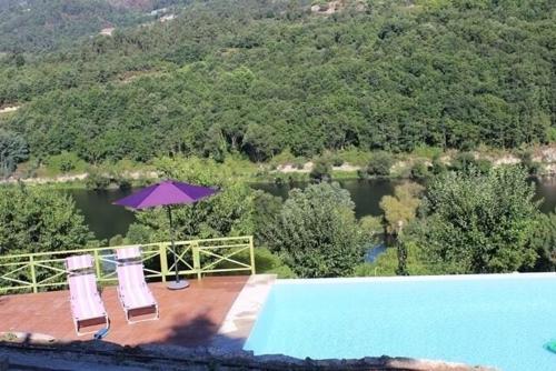 Casa antiga de pedra com piscina e vista rio