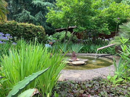 Grande maison en pierre, calme, jardin arboré.
